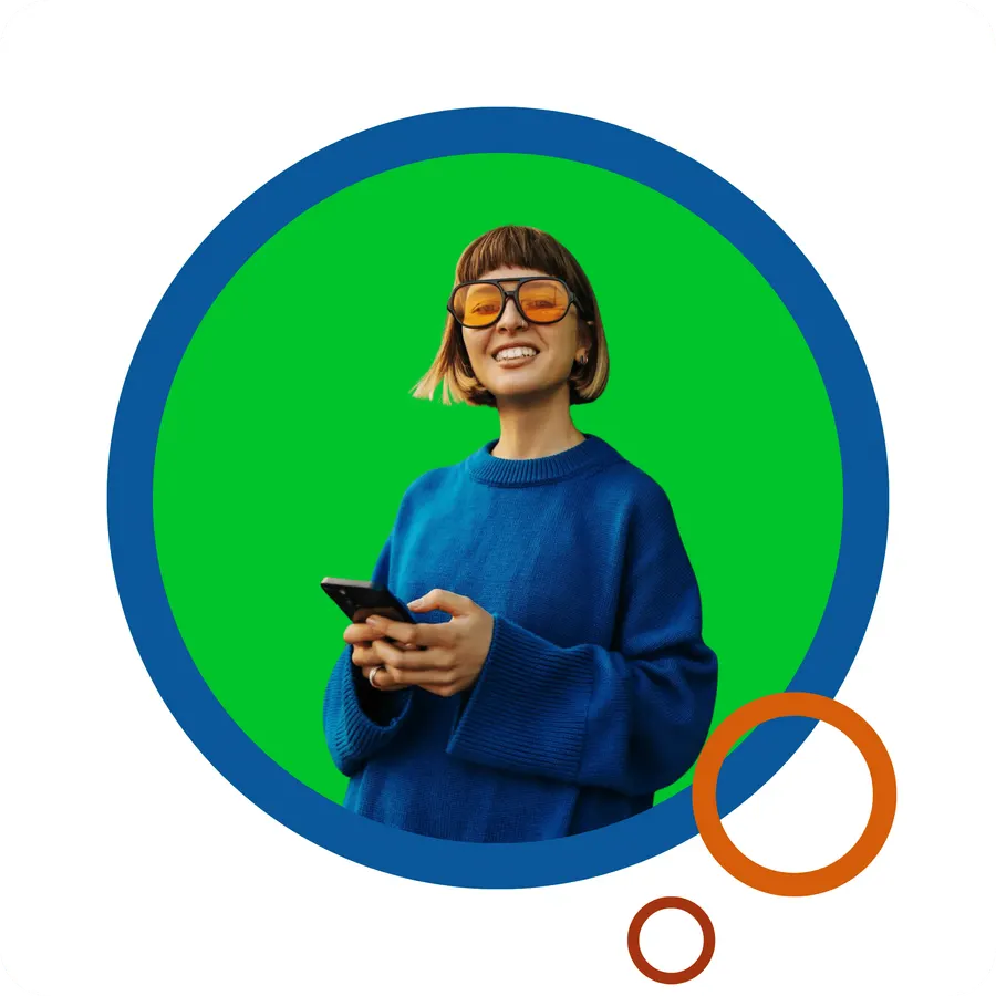 A student smiling while using a phone